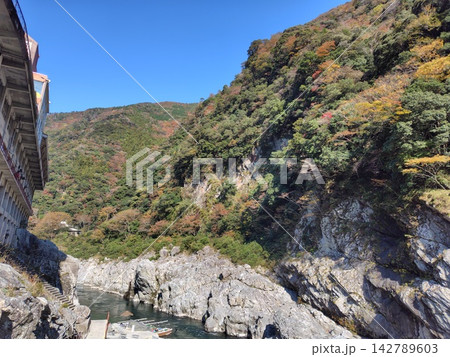 青空の下に広がる大歩危峡の白い岩肌と観光遊覧船乗り場の風景 142789603