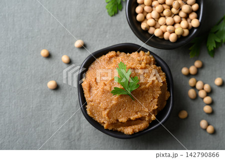 Miso paste in a black bowl. Traditional fermented soybean seasoning for Japanese cuisine Miso paste in a black bowl. Traditional fermented soybean seasoning for Japanese cuisine 142790866