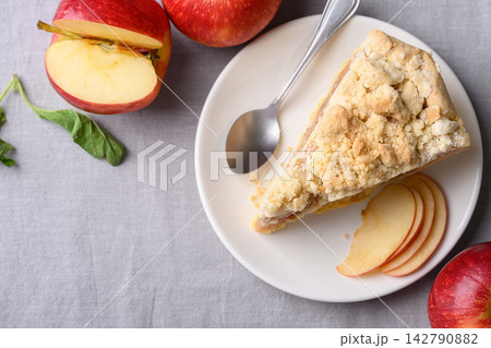 Apple crumble pie slice on white plate and fresh apple fruit Apple crumble pie slice on white plate and fresh apple fruit 142790882