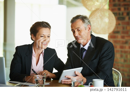 Tablet, desk and mature business people for meeting with internet research, cooperation and planning investment strategy. Financial advisor, man and woman by table with tech and consultation notes Tablet, desk and mature business people for meeting with internet research, cooperation and planning investment strategy. Financial advisor, man and woman by table with tech and consultation notes 142791011