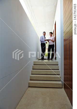 Business, people and hallway with discussion on tablet for teamwork, collaboration and planning for solution on project growth. Professional, man and documents for support, advice and schedule Business, people and hallway with discussion on tablet for teamwork, collaboration and planning for solution on project growth. Professional, man and documents for support, advice and schedule 142791403