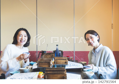 旅行先の宿やレストランで和食ランチ・朝食を笑顔で楽しむミドル世代の女性二人 142791564