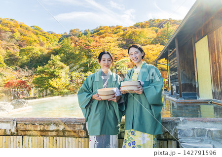 露天風呂で湯桶を持つ浴衣姿のミドル女性 142791596