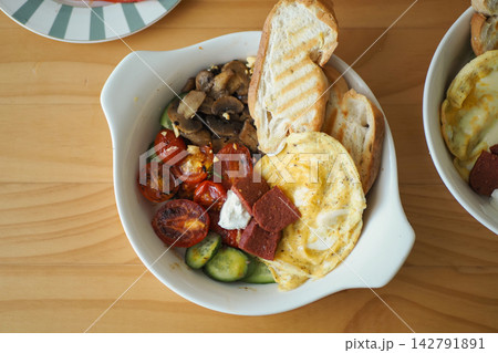 Delicious breakfast bowl with eggs, vegetables, and toasted bread Delicious breakfast bowl with eggs, vegetables, and toasted bread 142791891