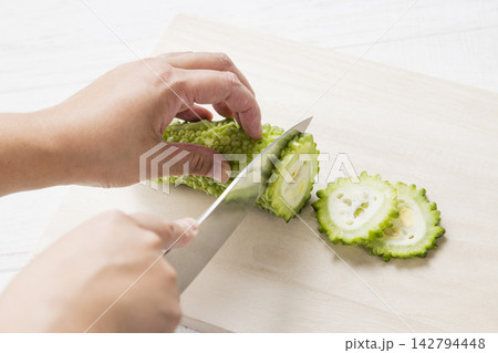 ゴーヤを包丁で輪切りにする手元 ゴーヤを包丁で輪切りにする手元 142794448