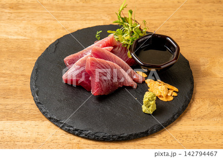 黒い石皿に盛られた美しいマグロの刺身 142794467