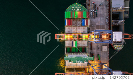 Aerial view container cargo ship loading unloading at night, Container cargo ship import export sea port, Global trade business container cargo ship freight shipping commercial trade logistic Aerial view container cargo ship loading unloading at night, Container cargo ship import export sea port, Global trade business container cargo ship freight shipping commercial trade logistic 142795702