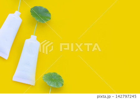 Fresh green centella asiatica leaves in cosmetic bottle on yellow background. Fresh green centella asiatica leaves in cosmetic bottle on yellow background. 142797245