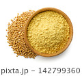 Ground mustard in a wooden bowl and mustard seeds isolated on a white background. Top view 142799360