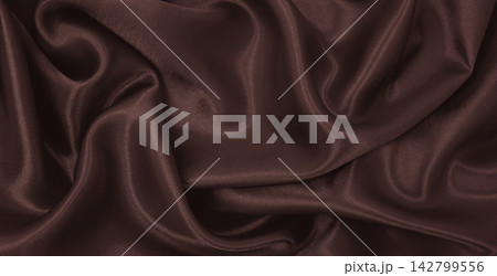 Smooth elegant brown silk or satin luxury cloth texture as abstract background. Luxurious background design. In Sepia toned. Retro style Smooth elegant brown silk or satin luxury cloth texture as abstract background. Luxurious background design. In Sepia toned. Retro style 142799556