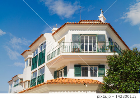 Building with white walls and an orange roof in Cascais on a sunny day with clear blue sky Building with white walls and an orange roof in Cascais on a sunny day with clear blue sky 142800115