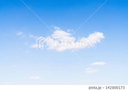 Clouds float in bright blue sky on a clear day in an open area with few visible clouds Clouds float in bright blue sky on a clear day in an open area with few visible clouds 142800173