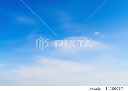 Clouds drift across a bright blue sky during daytime hours in a clear weather scene Clouds drift across a bright blue sky during daytime hours in a clear weather scene 142800174
