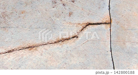 Weathered concrete surface with structural cracks and rust stains. 142800188
