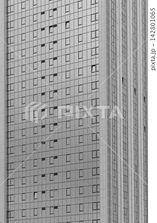 Monochrome high rise building facade with repeating windows. Abstract urban architecture with vertical lines and geometric pattern. Ideal for real 142801065