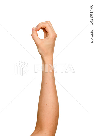 Woman s fingers forming a circular grip in mid-air. Left arm raised holding an invisible round 142801440