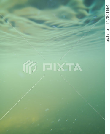 Calm turquoise water surface creates soft light waves over deep subaquatic space. Abstract Calm turquoise water surface creates soft light waves over deep subaquatic space. Abstract 142801664