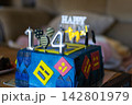 Vibrant blue 14th birthday cake featuring silver candles and playful geometric designs evokes youthful energy and gaming fun. Ideal for a teenage milestone celebration. Nobody. 142801979