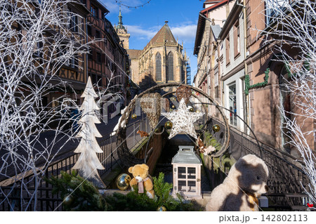 フランス・コルマール、クリスマスの飾りが彩る運河と歴史的な教会を望む美しい街並みとストリート風景 142802113