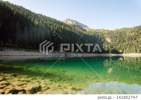 Beautiful view of lake. Rocky shore of mountain lake in the morning. Travelling, lifestyle, nature Beautiful view of lake. Rocky shore of mountain lake in the morning. Travelling, lifestyle, nature 142802747