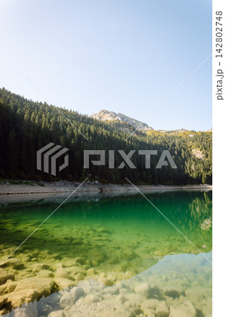 Beautiful view of lake. Rocky shore of mountain lake in the morning. Travelling, lifestyle, nature Beautiful view of lake. Rocky shore of mountain lake in the morning. Travelling, lifestyle, nature 142802748