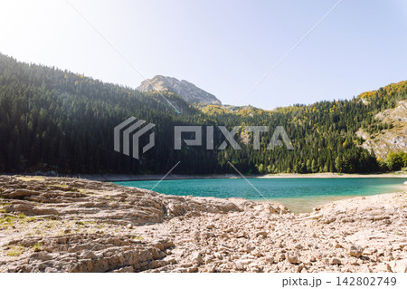 Beautiful view of lake. Rocky shore of mountain lake in the morning. Travelling, lifestyle, nature Beautiful view of lake. Rocky shore of mountain lake in the morning. Travelling, lifestyle, nature 142802749