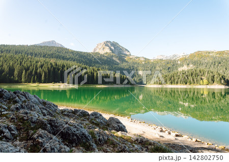 Beautiful view of lake. Rocky shore of mountain lake in the morning. Travelling, lifestyle, nature Beautiful view of lake. Rocky shore of mountain lake in the morning. Travelling, lifestyle, nature 142802750