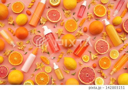 Cosmetic bottles on bright citrus fruits and flowers background, natural scincare cosmetics, beauty and facial care concept image, selective focus, shallow DOF 142803151