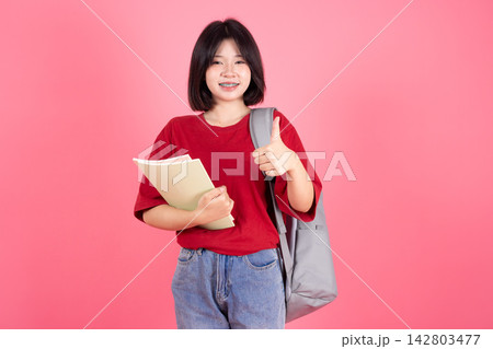 Asian Female Student Backpack Hand Thumbs up on Pink Studio Background for Good Education Asian Female Student Backpack Hand Thumbs up on Pink Studio Background for Good Education 142803477