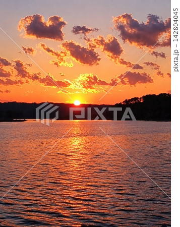 燃えるような夕空と黄金に煌めく静かな水面 燃えるような夕空と黄金に煌めく静かな水面 142804045