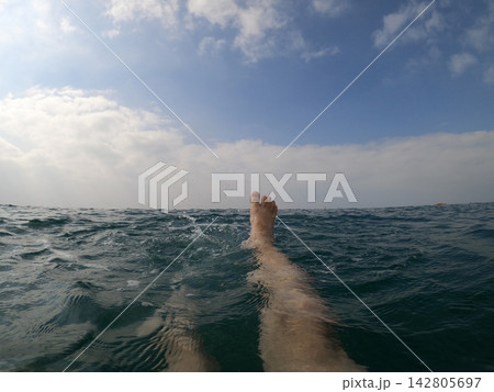 feet of a man swimming in the sea 142805697