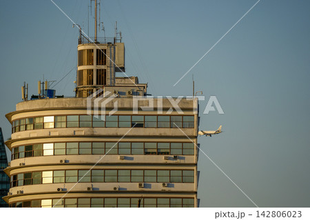 Airplane Flying Past Art Deco Skyscraper in Buenos Aires 142806023