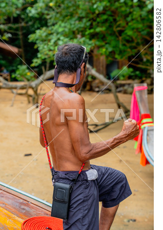 Beach local boatman preparing longtail boat for journey Beach local boatman preparing longtail boat for journey 142806582