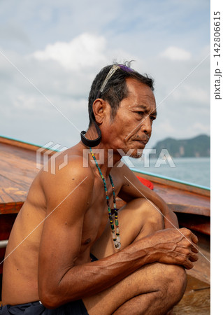 Fisherman sitting on longtail boat in thailand Fisherman sitting on longtail boat in thailand 142806615