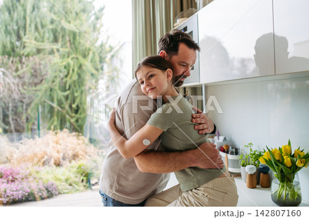 Dad hugging with daughter with diabetes in kitchen at home. 142807160