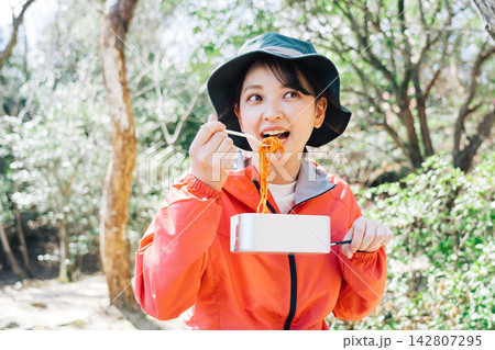 登山でメスティンを使った料理を食べる女性 登山でメスティンを使った料理を食べる女性 142807295