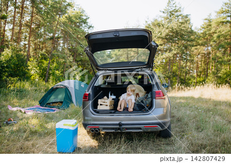 Family getting camping equipment from car after arriving in nature. Family getting camping equipment from car after arriving in nature. 142807429