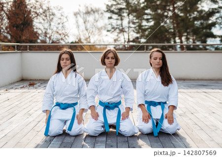 Confident women training karate together. Confident women training karate together. 142807569