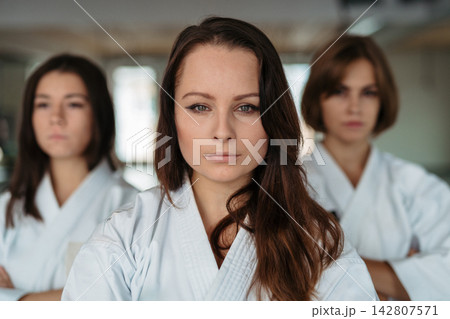 Confident women training karate together. Confident women training karate together. 142807571