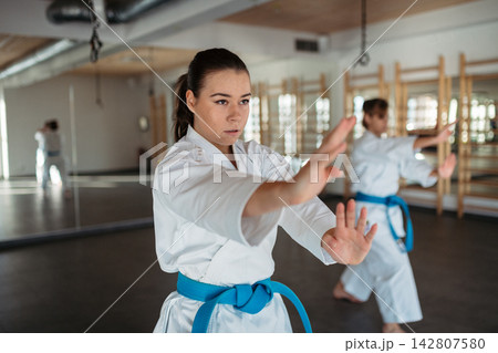 Women practicing karate kata in martial arts studio. Women practicing karate kata in martial arts studio. 142807580