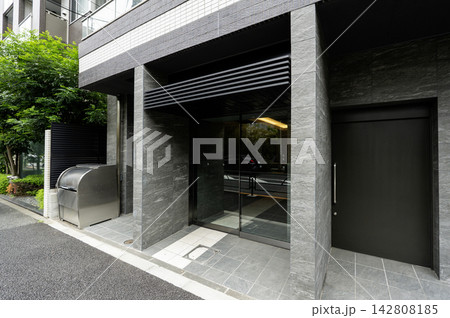 都市部に建つモダンでシックなワンルームマンションのエントランス 都市部に建つモダンでシックなワンルームマンションのエントランス 142808185