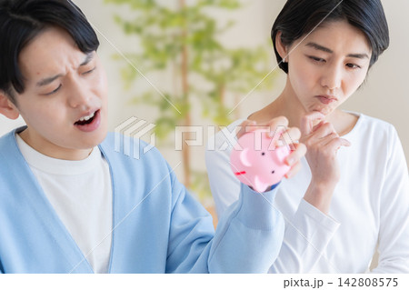 ブタの貯金箱と夫婦 142808575