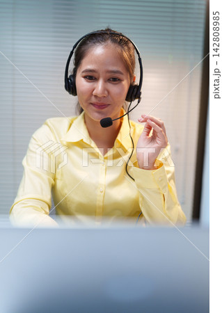 Female Call Center Assistant Wearing Headset at Work 142808985