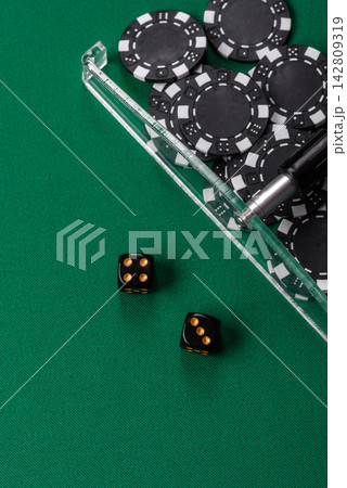 Dice and chips on a green felt gaming table, a poker game in a casino. Casino dice Dice and chips on a green felt gaming table, a poker game in a casino. Casino dice 142809319