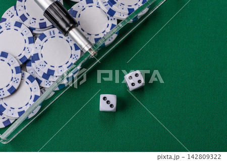 Dice and chips on a green felt gaming table, a poker game in a casino. Casino dice Dice and chips on a green felt gaming table, a poker game in a casino. Casino dice 142809322