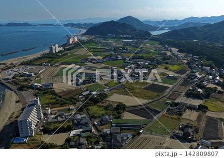 徳島県鳴門市の沿岸部・田畑・住宅街・山並みを望む空撮写真 徳島県鳴門市の沿岸部・田畑・住宅街・山並みを望む空撮写真 142809807