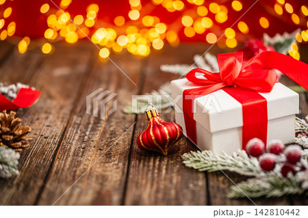Classic White Gift Box with Red Ribbon on Wood with Pinecone 142810442
