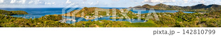 Panoramic view of sailboats docked in English Harbour and the surrounding green hills of Nelson's Dockyard National Park in Antigua. 142810799