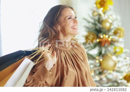 Festive Woman with Golden Blouse and Holiday Shopping Festive Woman with Golden Blouse and Holiday Shopping 142811082