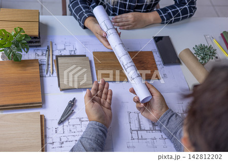 Professionals reviewing different laminate or wood-plastic composite options for a design project. Professionals reviewing different laminate or wood-plastic composite options for a design project. 142812202